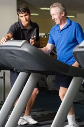 Athletic trainer helps man who is on a treadmill